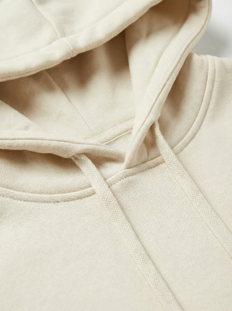 Zbliżenie na wysokiej jakości materiał i wykończenie beżowej bluzy z kapturem wear the way